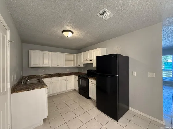 a kitchen with a refrigerator and a stove top oven