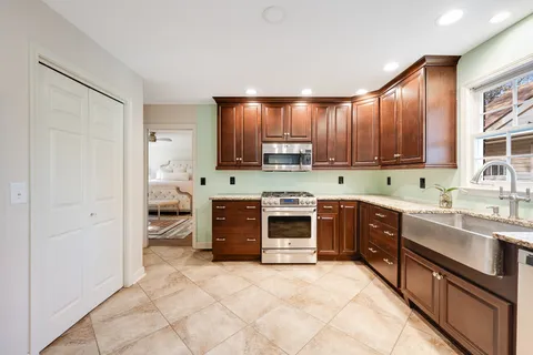 a kitchen with stainless steel appliances granite countertop a refrigerator and a sink