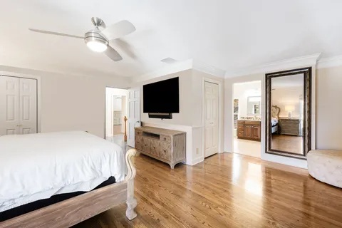 a spacious bathroom with a granite countertop double vanity sink a mirror and a bathtub