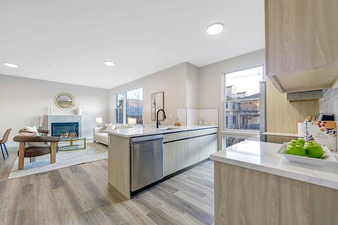 304 61st Street, Unit 2C West New York, NJ 07093 - Photo 37 of 44 a large white kitchen with stainless steel appliances a lot of counter space and a wooden floor