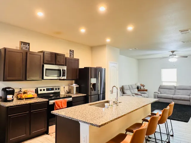 a kitchen with stainless steel appliances granite countertop a sink stove and refrigerator