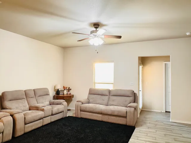a living room with furniture and a ceiling fan