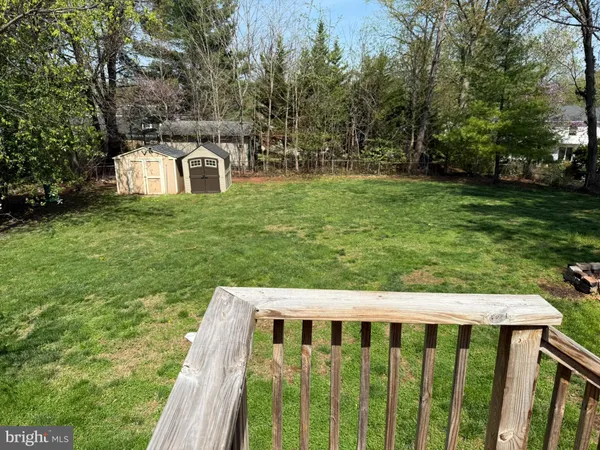 a view of a deck with a big yard and large trees