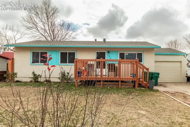 a backyard of a house with deck and barbeque oven