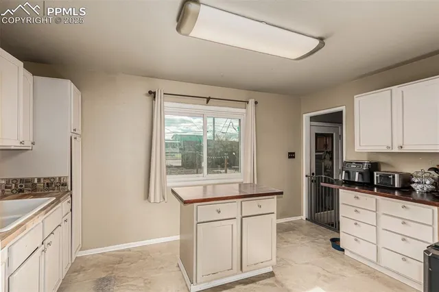 a kitchen with granite countertop white cabinets and white appliances