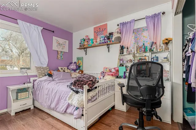 a bedroom with a bed and a chair with the bookshelf