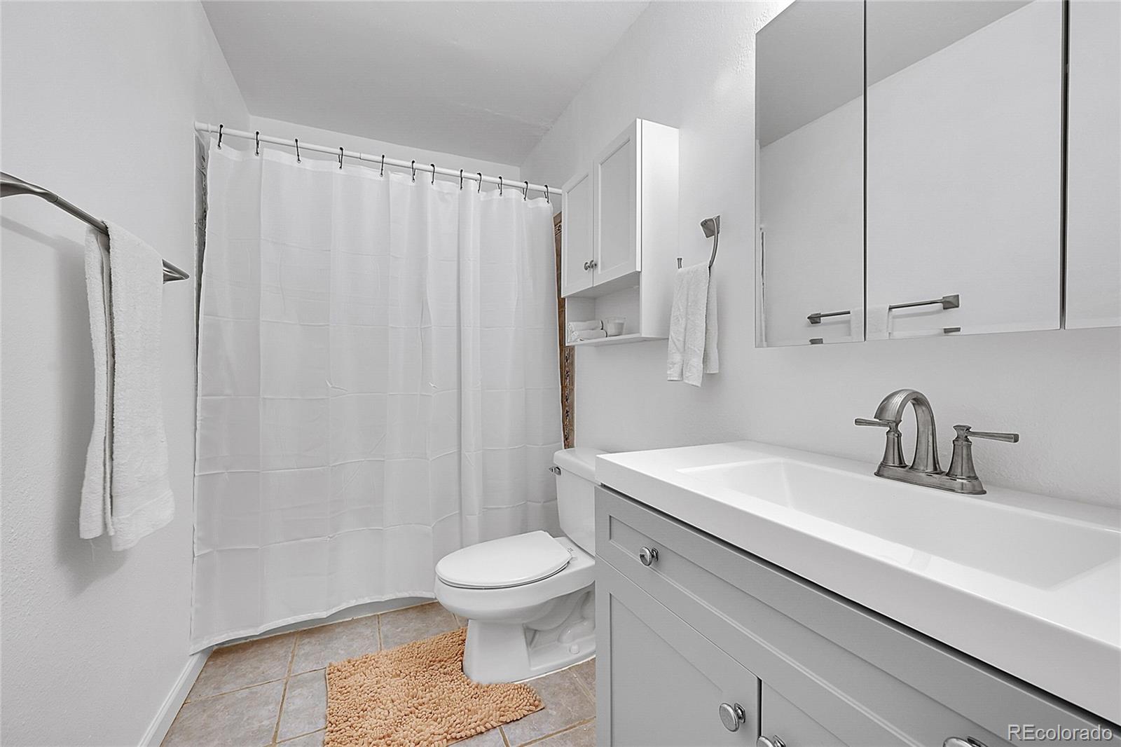 10251 West 44th Avenue, Unit 7108 Wheat Ridge, CO 80033 - Photo 13 of 21 a bathroom with a sink a toilet and shower