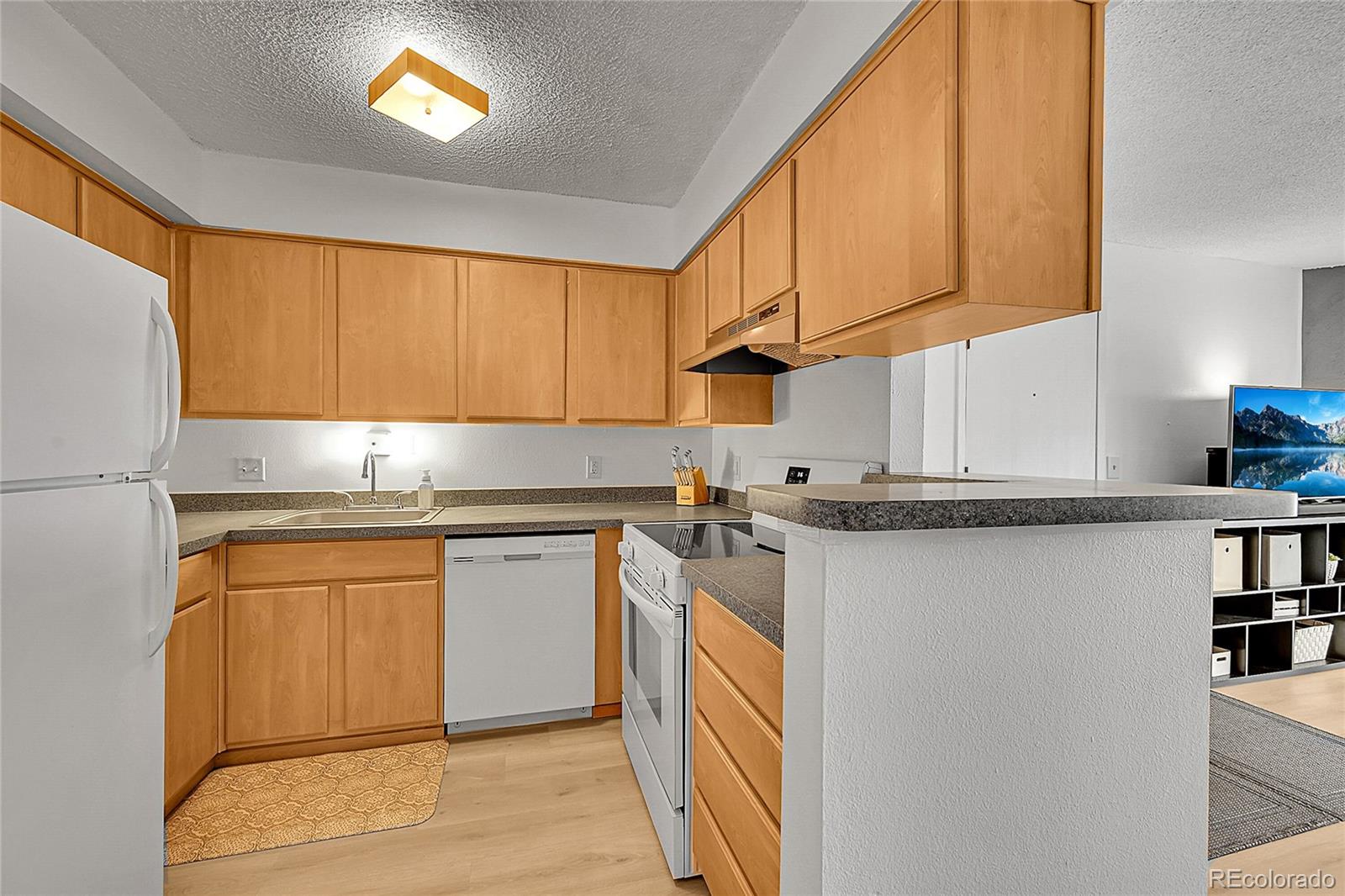 10251 West 44th Avenue, Unit 7108 Wheat Ridge, CO 80033 - Photo 8 of 21 a kitchen with stainless steel appliances granite countertop a refrigerator sink and cabinets