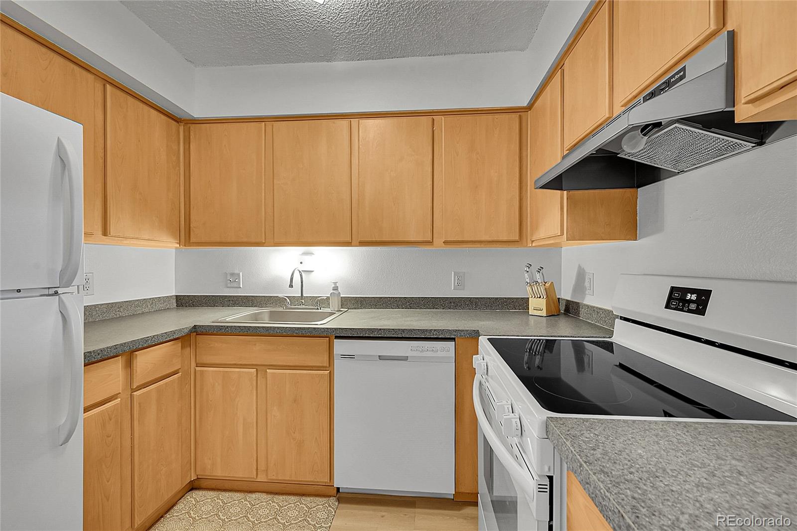 10251 West 44th Avenue, Unit 7108 Wheat Ridge, CO 80033 - Photo 9 of 21 a kitchen with a sink stove and cabinets