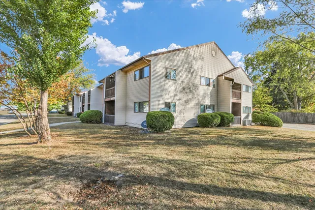 a view of a hallway with wooden floor and a bathroom