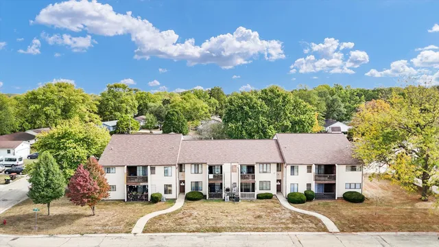 an aerial view of a house with a yard and a large tree