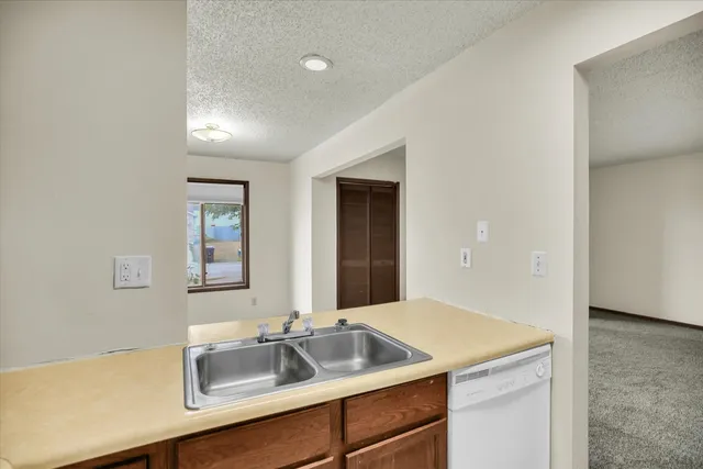 a view of a white house with a yard and potted plants