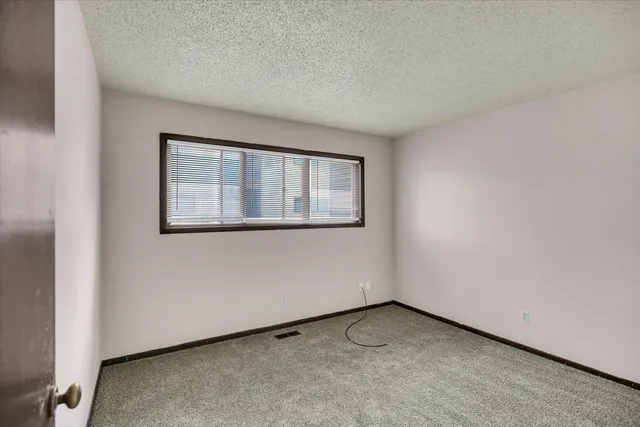 a view of a white house with a yard and potted plants