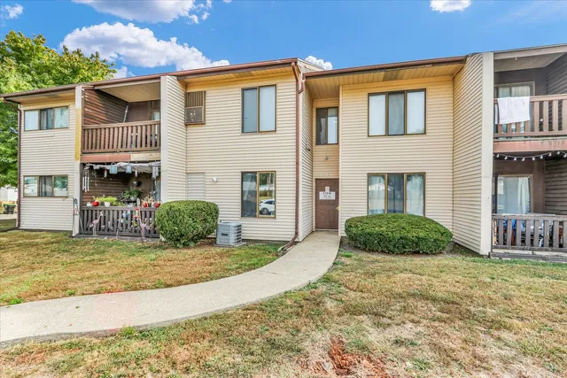 a view of a white house with a yard and garage
