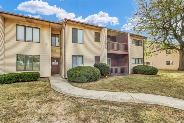 a front view of a house with basket ball court and potted plants