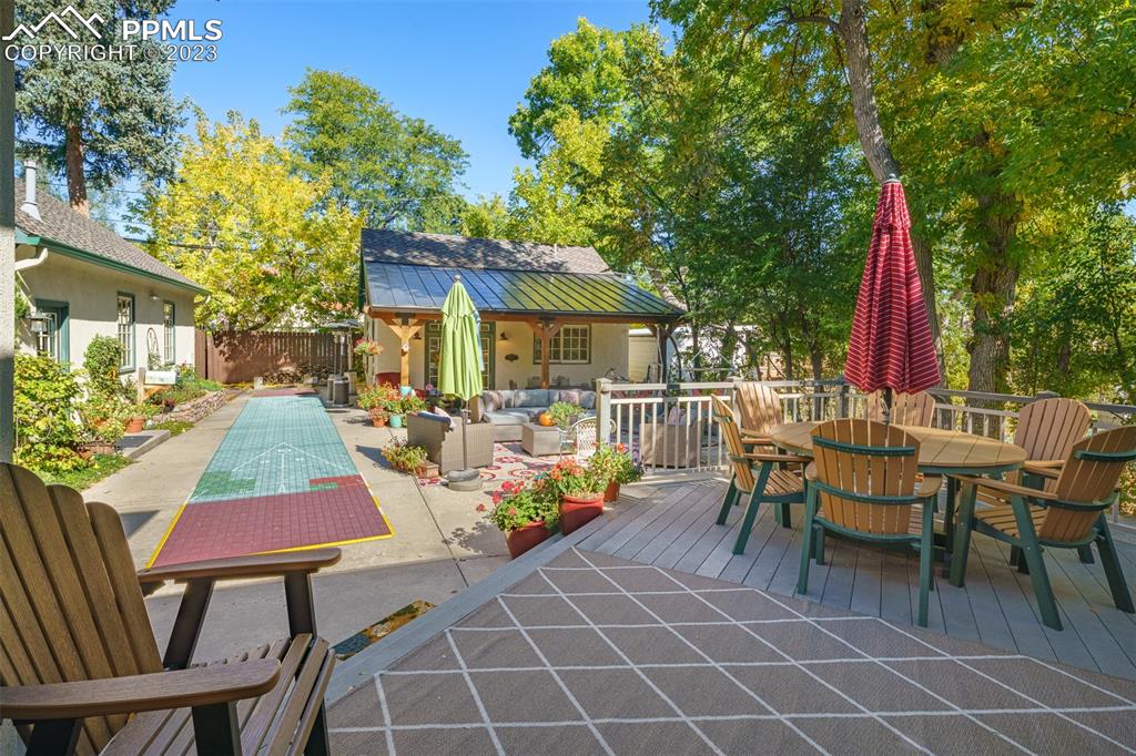 7 5th Street Colorado Springs, CO 80906 - Photo 34 of 46 a view of a patio with a dining table and chairs with wooden floor and fence