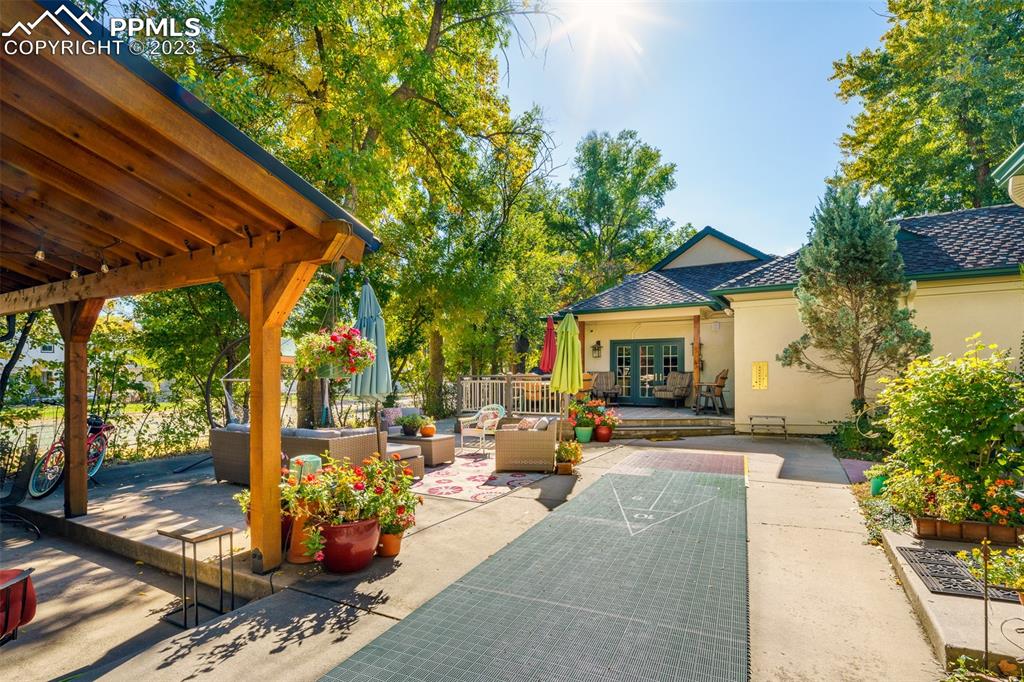7 5th Street Colorado Springs, CO 80906 - Photo 38 of 46 a view of a patio with table and chairs potted plants and a large tree