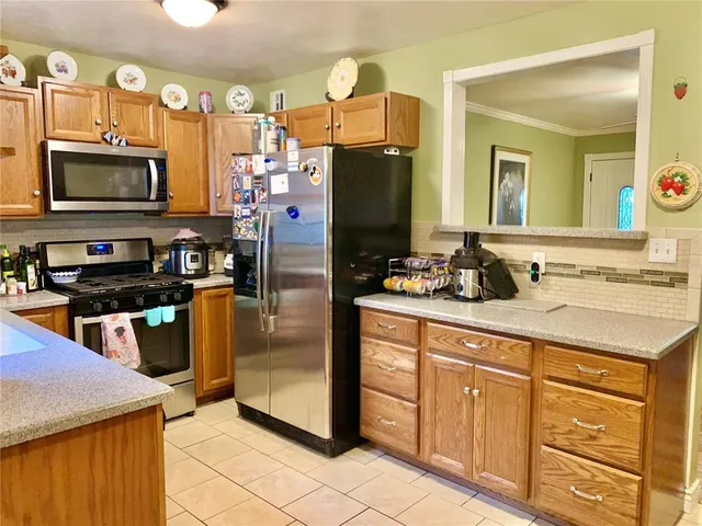 a kitchen with stainless steel appliances granite countertop a refrigerator a stove and a sink with wooden floor
