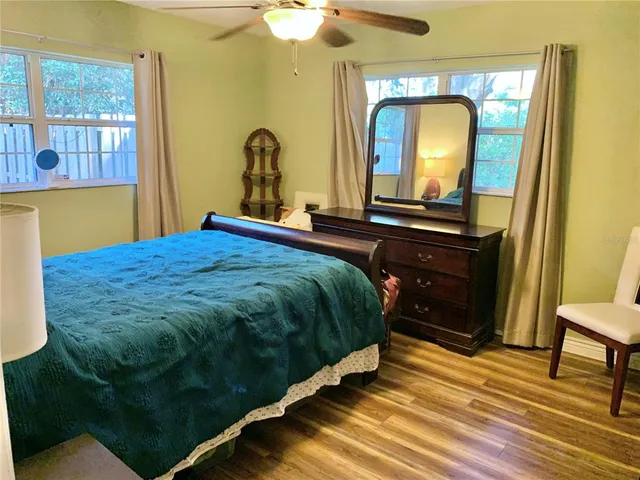 a bedroom with a bed and a mirror on dresser
