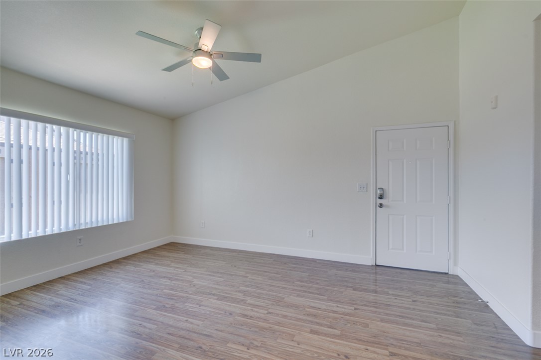 6650 West Warm Springs Road, Unit 2118 Las Vegas, NV 89118 - Photo 26 of 41 A well-lit room with wood flooring, featuring a practical ceiling fan and secure entry door.