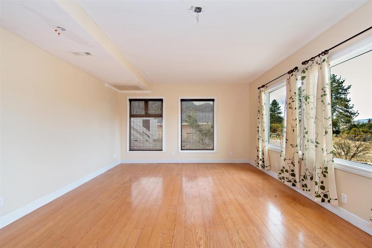 59911 Hop Patch Spring Road Mountain Center, CA 92561 - Photo 3 of 42 a view of an empty room with a window and wooden floor
