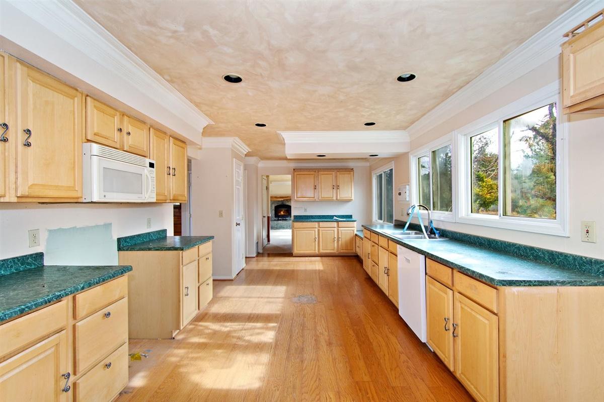 59911 Hop Patch Spring Road Mountain Center, CA 92561 - Photo 10 of 42 a large kitchen with stainless steel appliances granite countertop a large counter top a stove a sink dishwasher and cabinets with wooden floor
