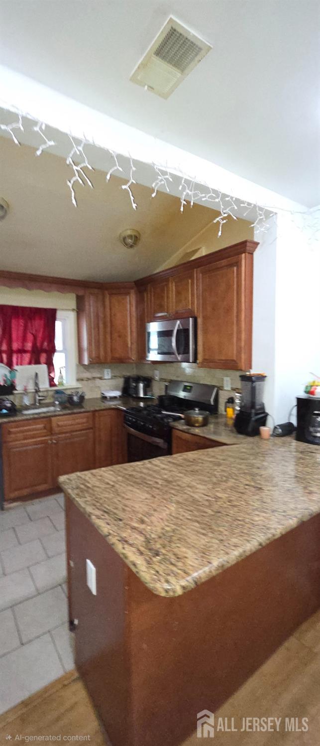 136 Smith Street Elizabeth, NJ 07201 - Photo 13 of 36 a kitchen with stainless steel appliances granite countertop a stove a sink dishwasher and a microwave oven with large trees