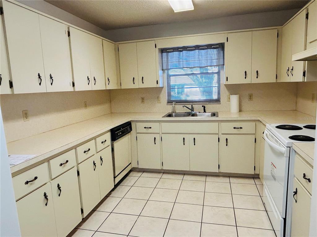 8530 Southwest 90th Street, Unit B Ocala, FL 34481 - Photo 11 of 45 a kitchen with granite countertop a sink a stove a microwave and cabinets