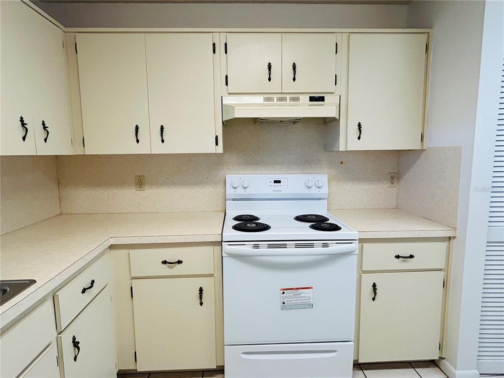 8530 Southwest 90th Street, Unit B Ocala, FL 34481 - Photo 14 of 45 a kitchen with white cabinets and white appliances