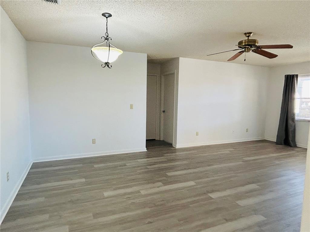8530 Southwest 90th Street, Unit B Ocala, FL 34481 - Photo 3 of 45 a view of an empty room with wooden floor and fan