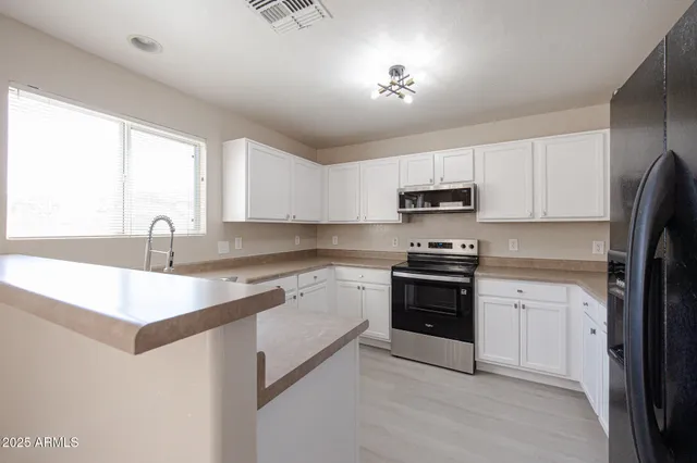 a kitchen with a sink appliances and cabinets