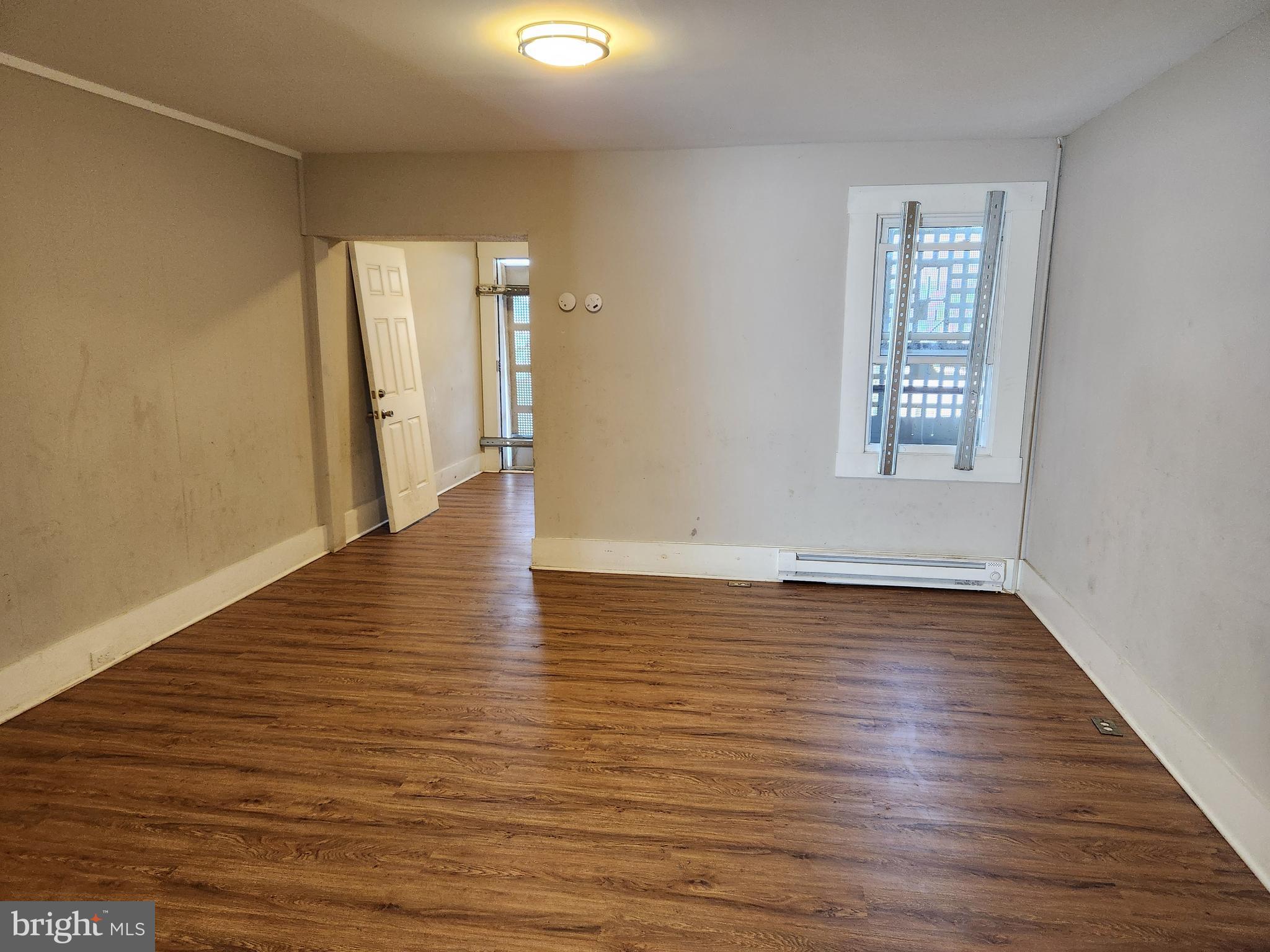 113 Eastern Boulevard Essex, MD 21221 - Photo 5 of 19 a view of an empty room with wooden floor and a window