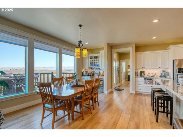 a dining room with furniture a chandelier and wooden floor