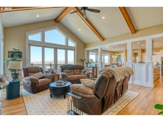 a living room with furniture a large window and a chandelier