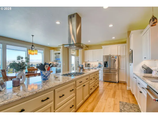 a large kitchen with kitchen island granite countertop a large counter top appliances and cabinets