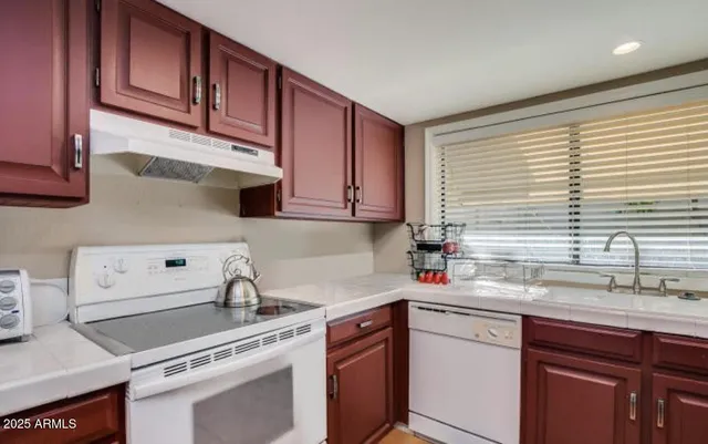 a kitchen with stainless steel appliances granite countertop a sink a stove and cabinets