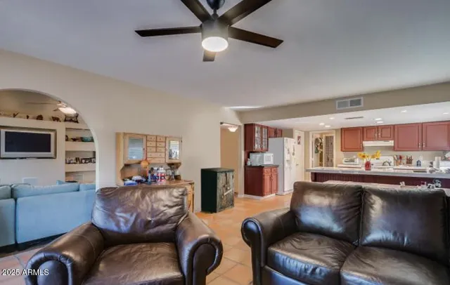 a living room with furniture a flat screen tv and kitchen view
