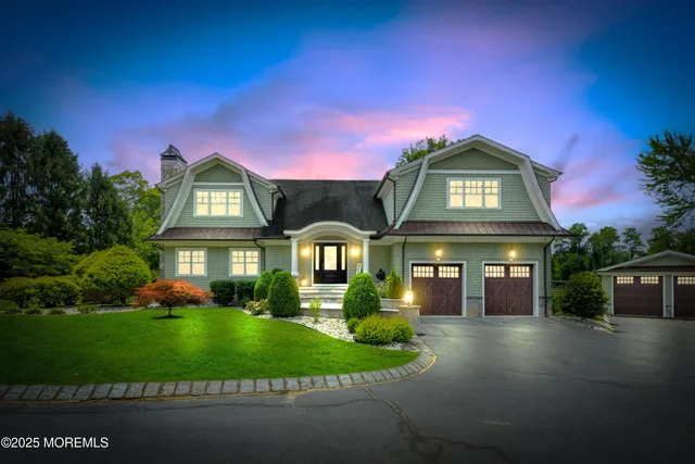 a front view of a house with a yard and potted plants