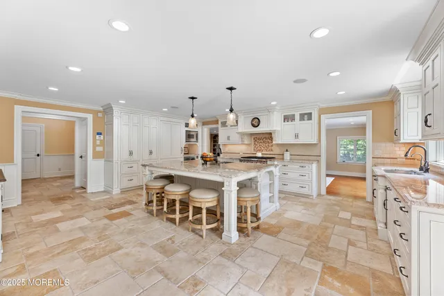 a large living room with stainless steel appliances granite countertop a couch a table and chairs in it