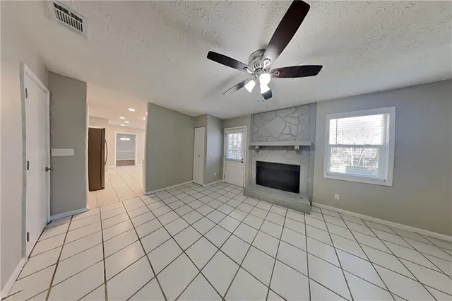 a view of a livingroom with a chandelier fan and windows