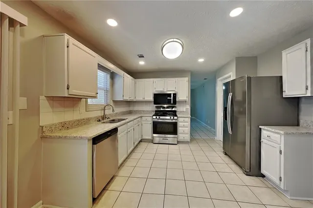 a kitchen with stainless steel appliances a refrigerator sink and cabinets