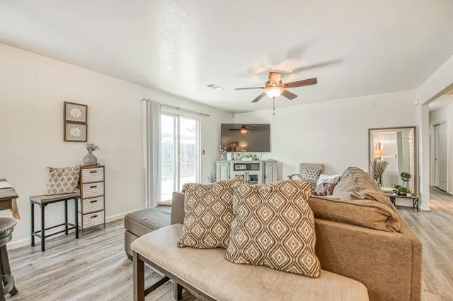 a living room with furniture a ceiling fan and a rug