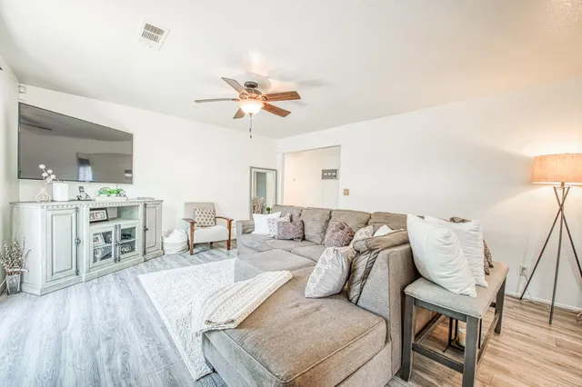 a living room with furniture and a wooden floor