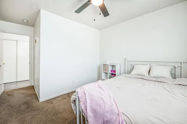 a bedroom with a bed and a ceiling fan