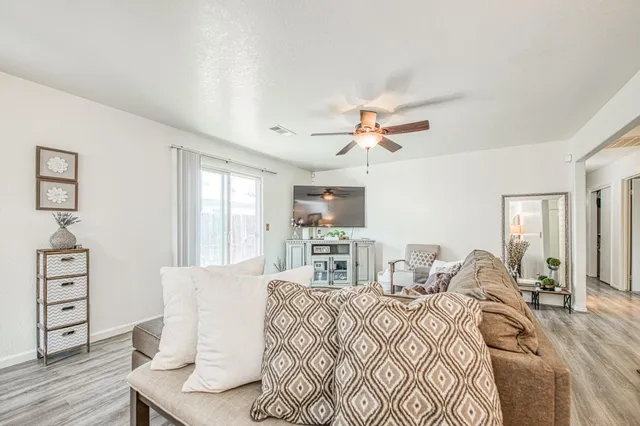 a living room with furniture and wooden floor