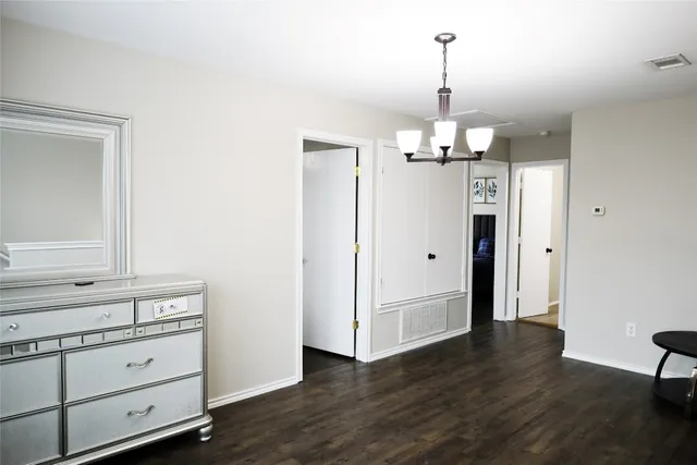 a view of a hallway with wooden floor and chandelier