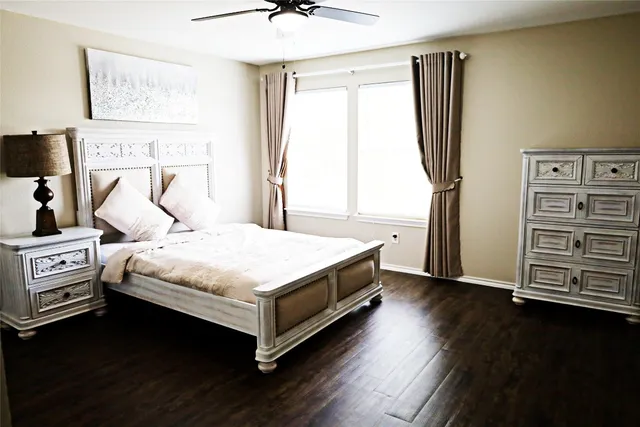 a bedroom with a bed and a flat tv screen on the dresser