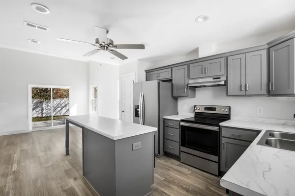 a kitchen with stainless steel appliances a stove a sink and a refrigerator
