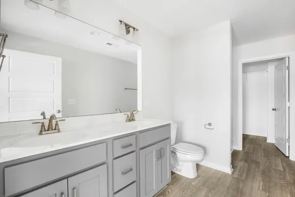 a bathroom with a granite countertop sink a toilet and a large mirror