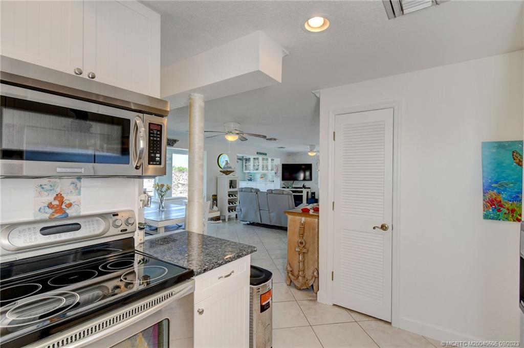 3541 Northeast Ocean Boulevard, Unit 19 Stuart, FL 34996 - Photo 52 of 52 a kitchen with granite countertop a stove and a microwave